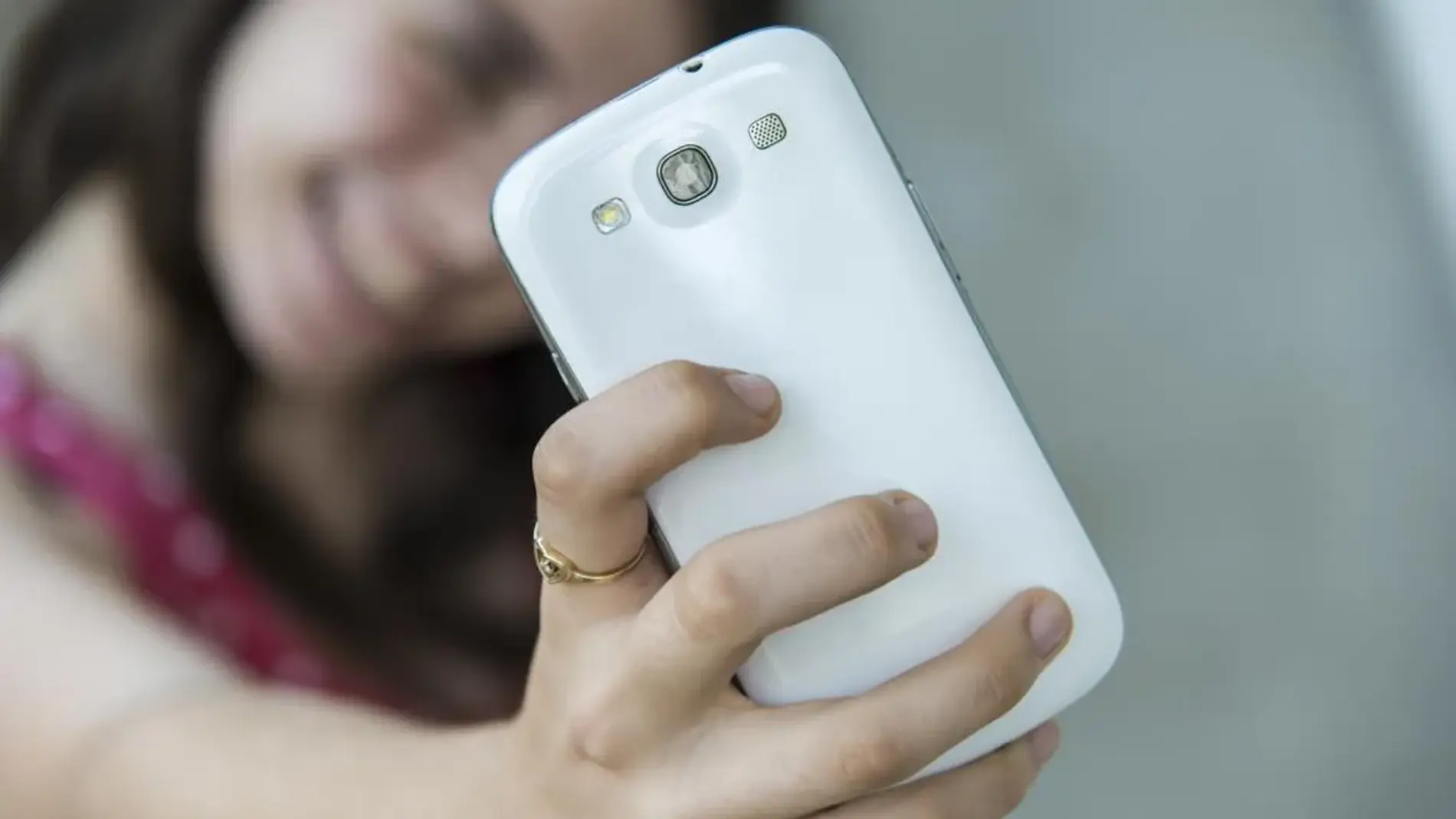 Una menor haciéndose un selfie con su móvil