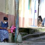 Una mujer descansa en una acera hoy, en el municipio de Valle de Ángeles (Honduras). La pandemia de COVID-19 acentuará la pobreza y la desigualdad en Honduras, donde la enfermedad no ha logrado detener la corrupción,