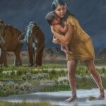 En una escena de la edad de hielo, una mujer sosteniendo a un niño a orillas del antiguo lago Otero deja las huellas en el barro.