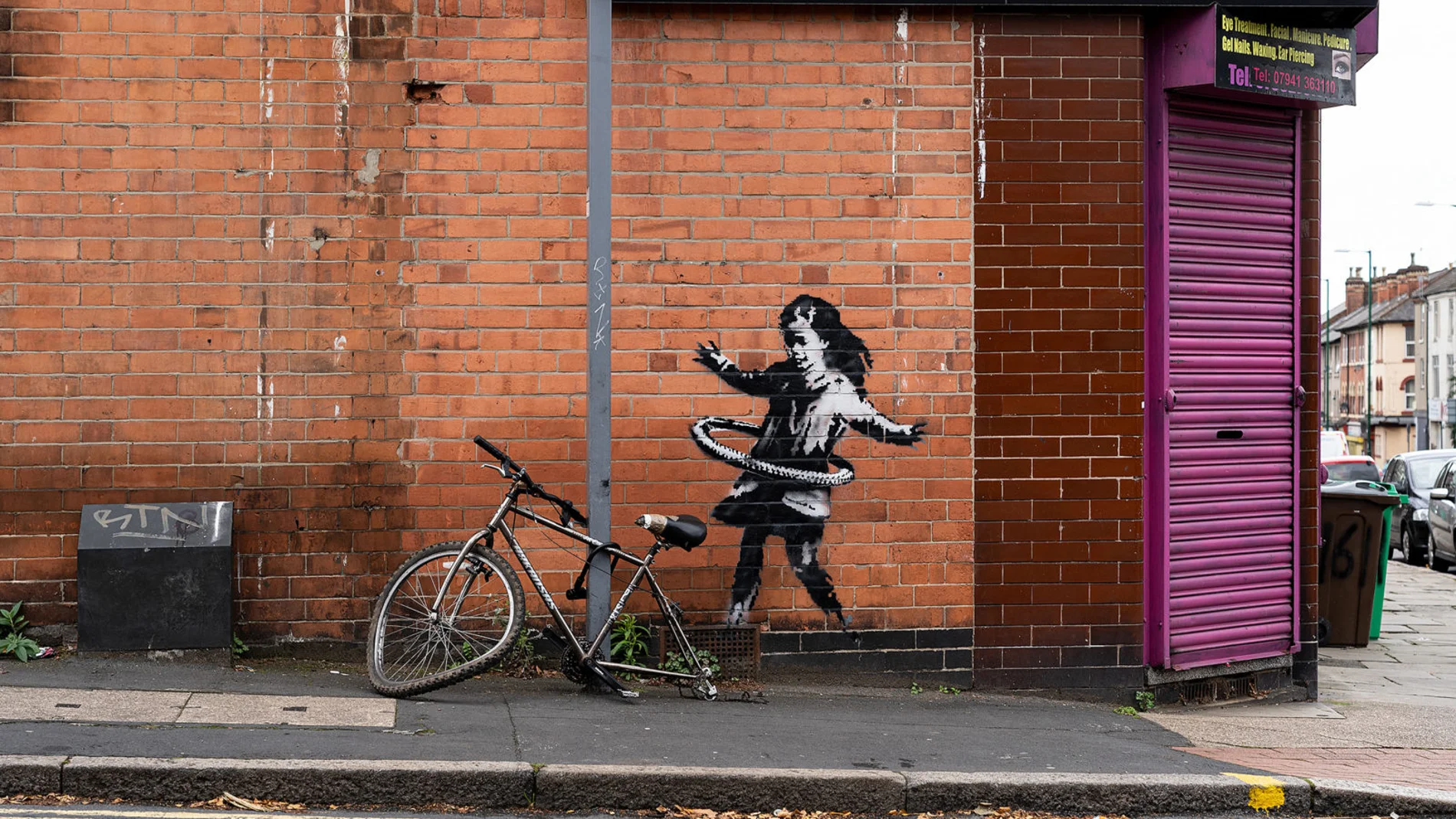 Obra de Bansky conocida con el sobrenombre de "Niña del hula-hula"