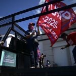 Former senator Miriam RamÃ­rez de Ferrer carries a pro-Trump flag moments before leaving for the headquarters of the Republican party in support of President Donald Trump's candidacy a few weeks before the presidential election next November, in Carolina, Puerto Rico, Sunday, Oct. 18, 2020. President Donald Trump and former Vice President Joe Biden are targeting Puerto Rico in a way never seen before to gather the attention of tens of thousands of potential voters in the battleground state of Florida. (AP Photo/Carlos Giusti)