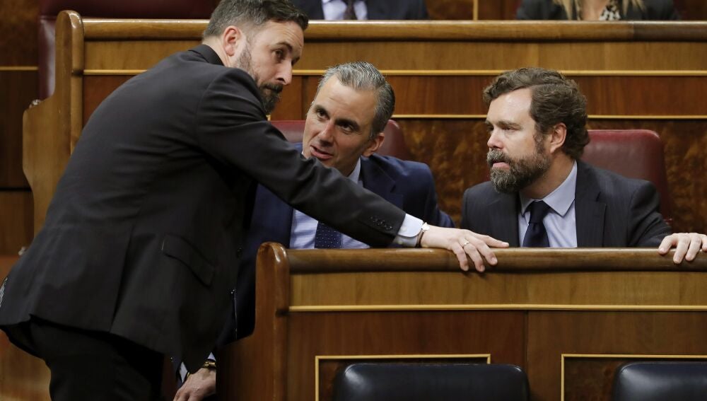 Los diputados de Vox Santiago Abascal, Javier Ortega Smith e Iván Espinosa de los Monteros durante el pleno del Congreso de los Diputados en el que se comienza a tramitar la regulación de la eutanasia, este martes en Madrid.