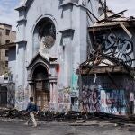 Agentes de la Policía de Investigaciones de Chile (PDI) trabajan cerca de la destruida parroquia de la Asunción, en Santiago (Chile)