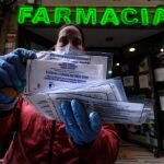 Entrega de mascarillas quirúrgicas a la entrada de una farmacia de Toledo