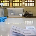 Ballots, gloves and alcohol sit on a table during a press tour of a voting center set up at a school in Santiago, Chile, Friday, Oct. 23, 2020, amid the COVID-19 pandemic. On Sunday, Oct. 25, Chileans will decide whether or not to rewrite the constitution that dates back to the dictatorship of Augusto Pinochet. (AP Photo/Esteban Felix)