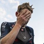 Tao Geoghegan Hart se lleva la mano a la cara después de ganar en Sestriere