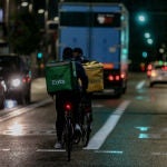 Un rider de Glovo y otro de Uber Eats durante un servicio