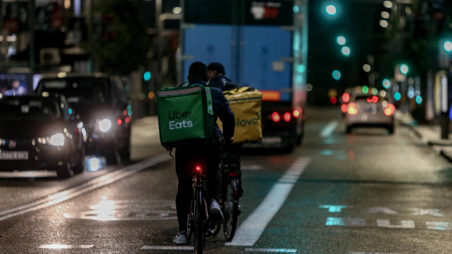 Un rider de Glovo y otro de Uber Eats durante un servicio