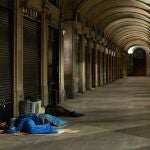 Personas sin hogar duermen en la Plaza Real de Barcelona
