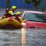 Los bomberos buscan supervivientes en un coche que ha quedado bloqueado por las inundaciones