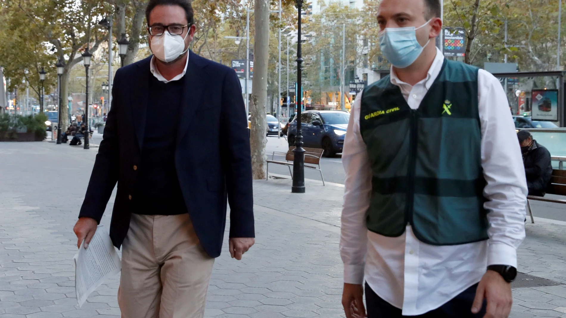 Agentes de la Guardia Civil custodian exalto cargo de CDC David Madí (i) a su llegada a su despacho profesional tras ser detenido