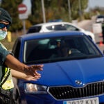 Un agente de la Guardia Civil le da el alto a un pasajero durante un control