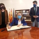 La vicepresidenta segunda del Congreso, Ana Pastor, firmando en el libro de honor de la Diputación Provincial de Alicante, con el presidente, Carlos Mazón, y la vicepresidenta Julia Parra, durante su visita al Palacio Provincial
