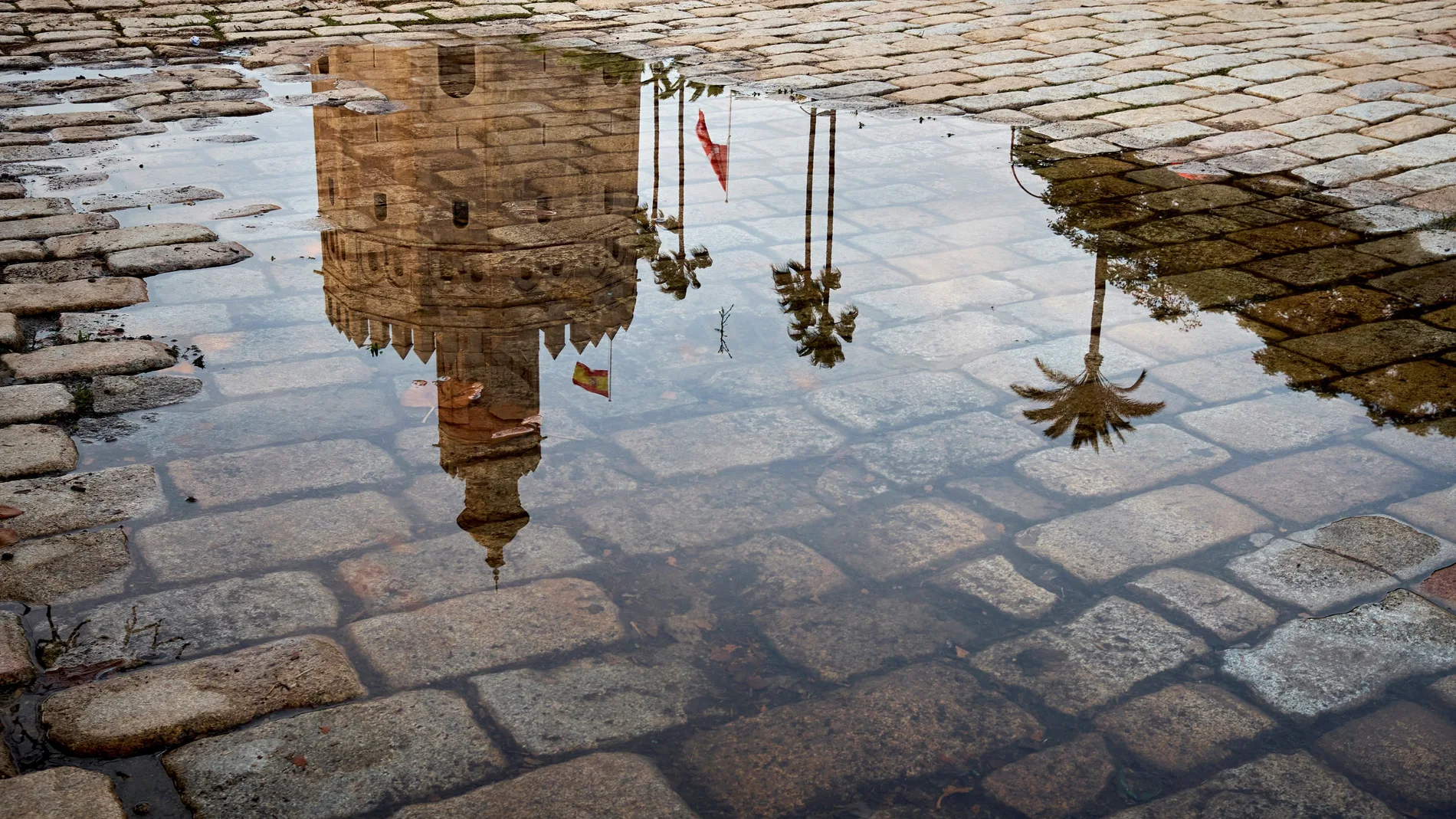 GRAF4789. SEVILLA (ESPAÑA), 05/11/2020.- La Torre del Oro de Sevilla reflejada este miércoles en un charco al atardecer, después de que la lluvia haya cesado causando pocas incidencias en la ciudad. EFE/Julio Muñoz