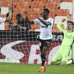 Courtois, de rodillas, mientras los jugadores del Valencia celebran un gol