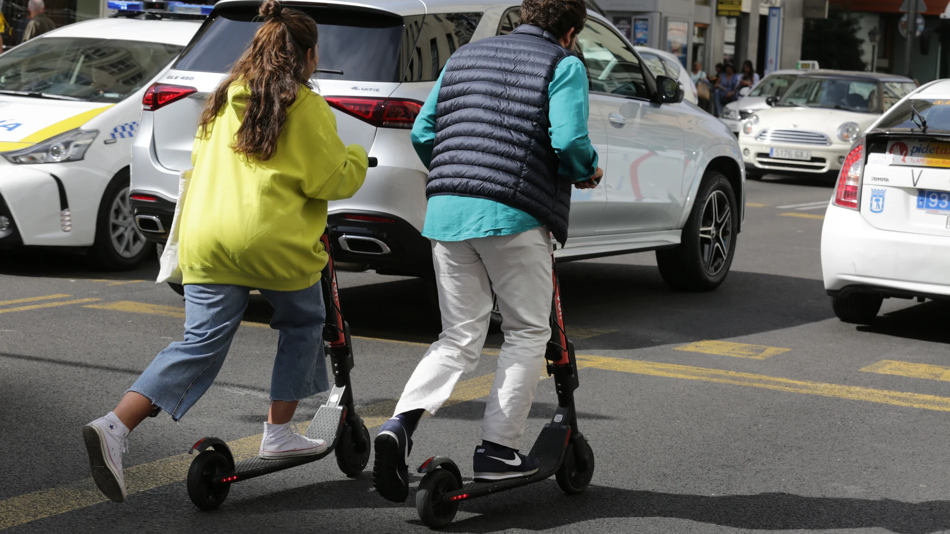 Dos personas van en patinete eléctrico.