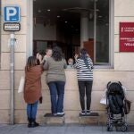 Una anciana recibe la visita de sus nietas a través de una ventana de la residencia de Velluters