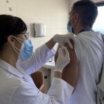 Un sanitario administra la vacuna contra la gripe