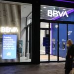 Una pareja pasa frente a una oficina del BBVA, este lunes en Bilbao