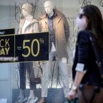 Una persona pasa ante un escaparate de un comercio con promociones del denominado "Black Friday"