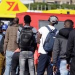 Miembros de la PolicÍa Nacional piden los papeles a algunos de los 200 inmigrantes de origen magrebÍ, que llegaron a las islas en los últimos días en pateras y cayucos y que se trasladaron gracias a la Cruz Roja a un hotel del sur de Tenerife. EFE/Ramón de la Rocha