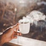 En la imagen, una taza de café humeando en el frío invierno.