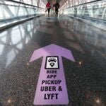 Travelers walk across a nearly empty skyway bridge towards the Uber and Lyft shared ride pick-up point at Logan Airport, Friday Nov. 20, 2020, in Boston. With the coronavirus surging out of control, the nation's top public health agency pleaded with Americans not to travel for Thanksgiving and not to spend the holiday with people from outside their household. (AP Photo/Michael Dwyer)
