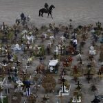 Workers ride their horses in the Valle de Chalco municipal cemetery, usually reserved to bury COVID-19 victims, on the outskirts of Mexico City, Wednesday, Nov. 18, 2020. Mexico topped 1 million registered coronavirus cases and nearly 100,000 test-confirmed deaths over the last week, though officials agree the number is probably much higher. (AP Photo/Marco Ugarte)