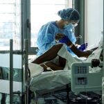 Un enfermo de Covid-19 es atendido por una fisioterapeuta en la UCI del hospital Son Espases de Palma de Mallorca.