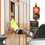 Imagen de un trabajador de peajes cobrando a un conductor