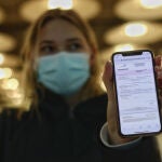 Una mujer de nacionalidad francesa enseña el negativo de su PCR en la terminal T4 del Aeropuerto de Madrid-Barajas Adolfo Suárez, en Madrid (España), a 23 de noviembre de 2020. Alemania exige desde hoy PCR negativa a 20 países, entre ellos España, considerados de "alto riesgo"