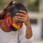 ACOMPAÑA CRÓNICA: VENEZUELA CRISIS AME270. CARACAS (VENEZUELA), 24/11/2020.- Fotografía que muestra una mujer mientras usa un tapabocas con la bandera de Venezuela el 11 de noviembre de 2020, en Caracas (Venezuela). Es muy posible que Elizabeth Garzón o Aracely Ponce no lo sepan, pero los países del mundo acordaron en 2015 mejorar, en los tres lustros siguientes, sus condiciones de vida a través de un proyecto: los Objetivos de Desarrollo Sostenible (ODS). Como a muchos venezolanos, ese plan les suena a chino y pelean en su día a día para tener agua o llegar a fin de mes. EFE/Miguel Gutiérrez