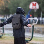 Una persona con un chubasquero bajo la lluvia