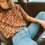 En la imagen, una chica posa en el coche y presume de vientre plano.