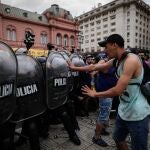 Un grupo de personas choca con la policía durante la espera para poder ingresar al velatorio de Diego Armando Maradona, hoy jueves en la Plaza de Mayo de Buenos Aires