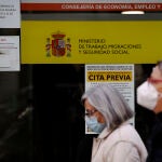Dos mujeres pasan por la puerta de una oficina de empleo