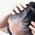 Mujer con canas en el pelo de la cabeza