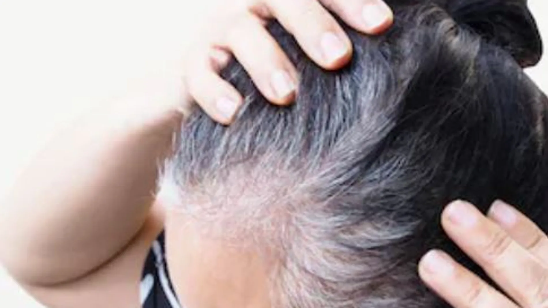 Mujer con canas en el pelo de la cabeza