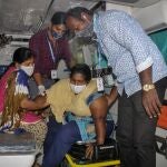Un paciente es asistido por otros para bajar de una ambulancia en el hospital de Eluru