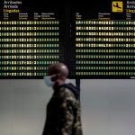 Un persona pasa frente al panel de llegadas del aeropuerto de València, adonde han llegado en avión en los últimos días un número indefinido de inmigrantes desde Canarias, asi como a otros puntos de la Península, entre ellos Granada, Málaga, Sevilla, Alicante en vuelos comerciales