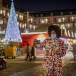 Un hombre con mascarilla se hace una foto en la Plaza Mayor