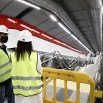 El consejero de Transportes, Movilidad e Infraestructuras de la Comunidad de Madrid, Ángel Garrido, y la presidenta de Adif, Isabel Pardo, conversan en el túnel que une las estaciones de de Metro Gran Vía con Cercanías de Sol.