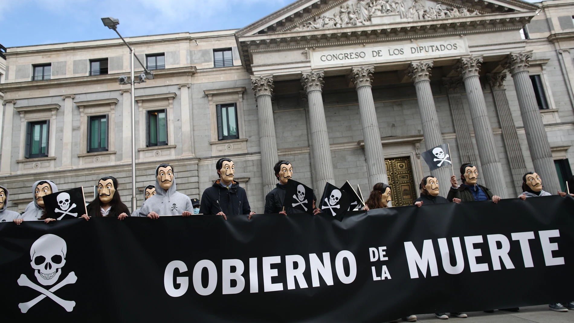 Manifestantes con máscaras de Dalí se concentran con pancartas con el símbolo de la muerte frente al Congreso de los Diputados, en Madrid