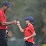 Tiger Woods y su hijo Charlie chocan los puños tras terminar su recorrido