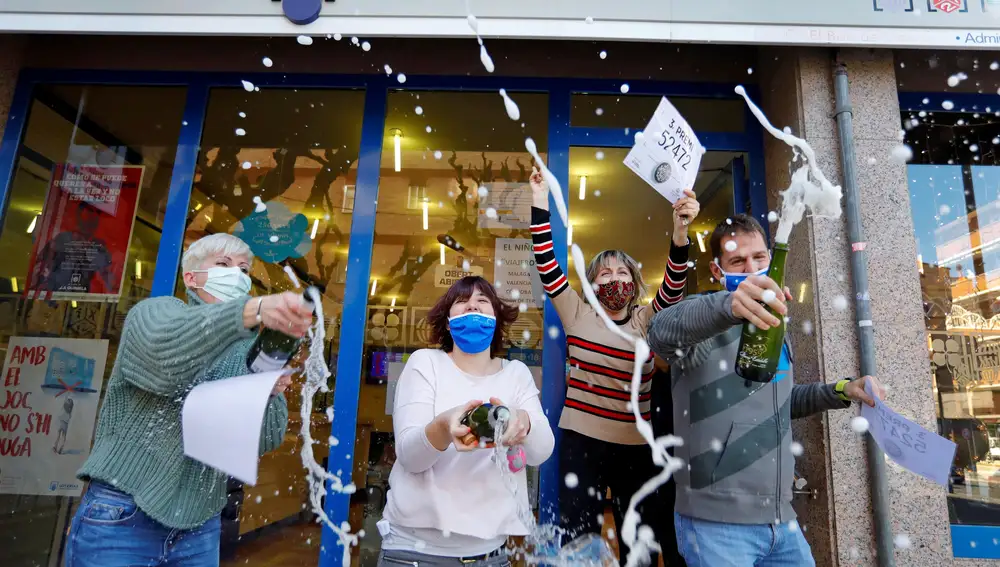 Un grupo de personas celebrando el premio de la Lotería de Navidad en la administración