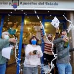 Un grupo de personas celebrando el premio de la Lotería de Navidad en la administración