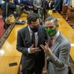 El presidente andaluz, Juanma Moreno, y el consejero de Hacienda, Juan Bravo (d), en el Parlamento de Andalucía