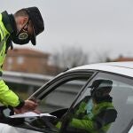 Un guardia civil solicita la documentación a un conductor en un control montado en la A-5 a la altura de la localidad madrileña de Navalcarnero | Fuente: EFE/Fernando Villar