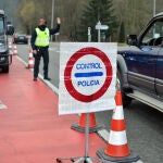 Un Mosso d'Esquadra para a un coche durante el control policial por el confinamiento perimetral en la C-17 a la entrada de Ripoll, en Girona.