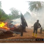 Terroristas de Daesh, con la bandera de la organización, mientras queman un poblado en el Congo